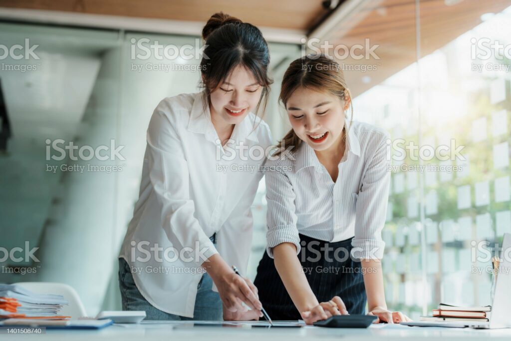 financial, Planning, Marketing and Accounting, portrait of Asian woman Economist using calculator to calculate investment documents with partners on profit taking to compete with other companies.